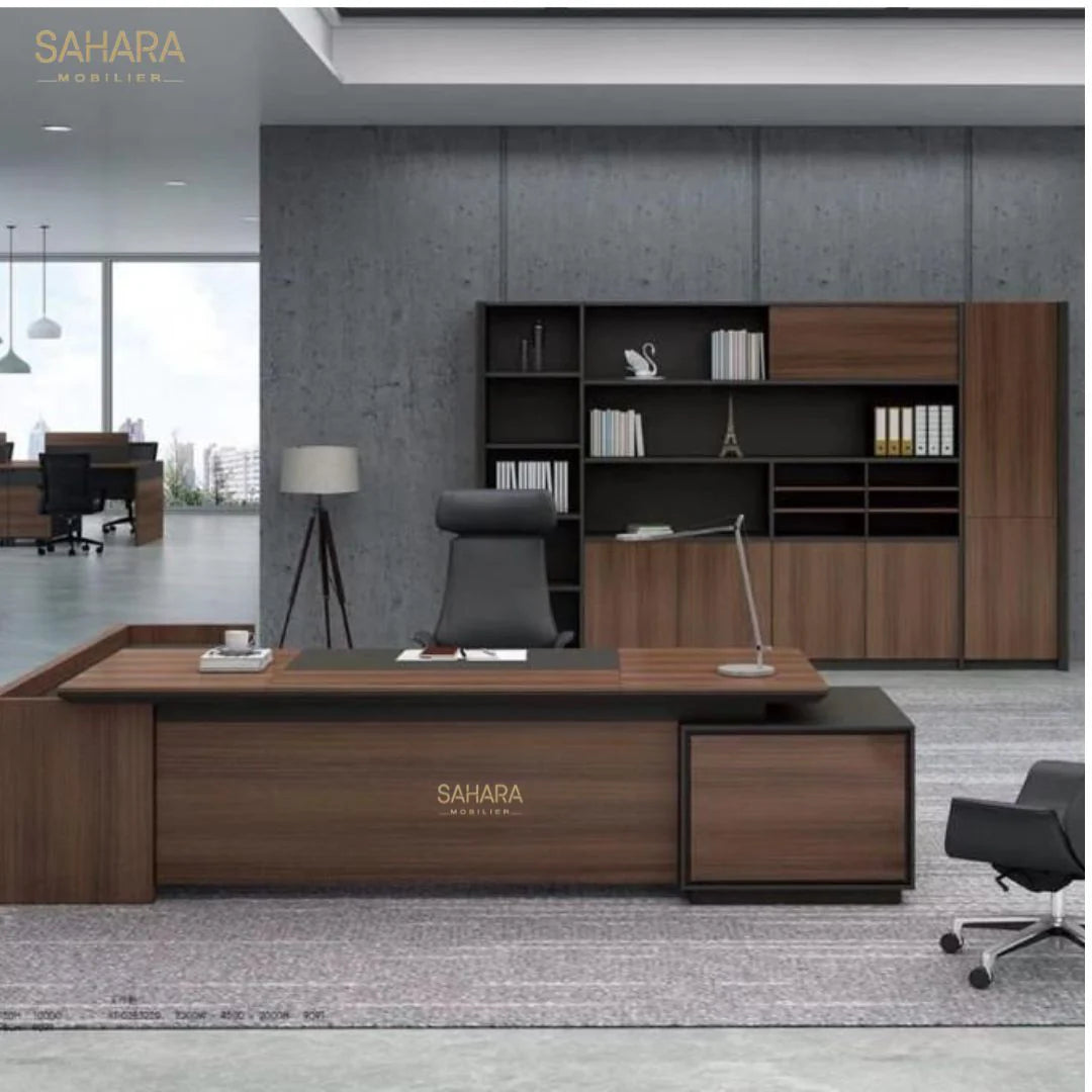 Bureau de direction avec retour fixe et caisson mobile avec sous main et 2 passe câbles exposé dans une salle avec fauteuil en simili cuir